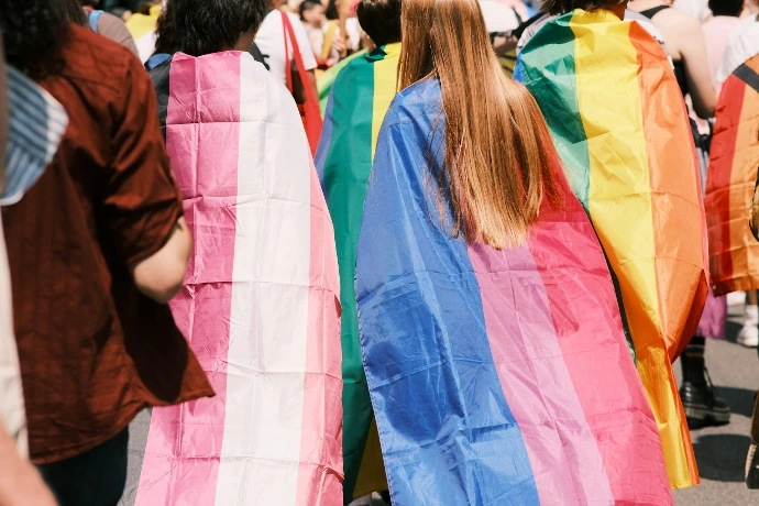 a group of people walking down a street holding rainbow flags